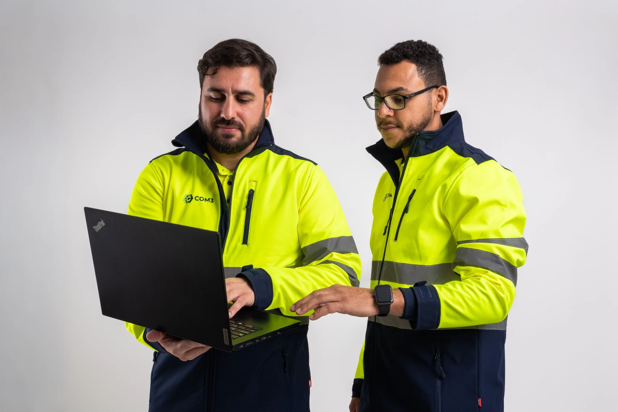 Profesionales de COM3 trabajando juntos con un ordenador portátil